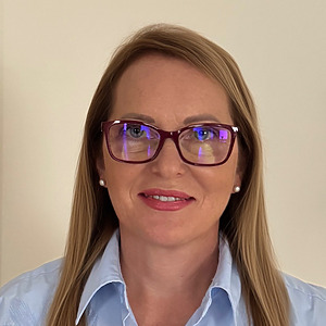 Lina Strumskienė pozuoja patalpoje. Jos &scaron;viesūs ir ilgi plaukai. Ji dėvi violetinius akinius ir &scaron;viesiai mėlynus mar&scaron;kinius.